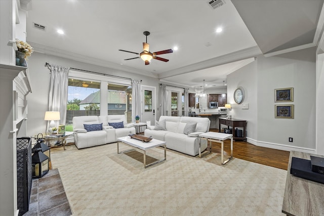 living room with hardwood / wood-style floors, ceiling fan, and crown molding