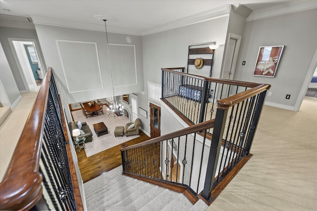 stairway with ornamental molding, carpet, and a notable chandelier