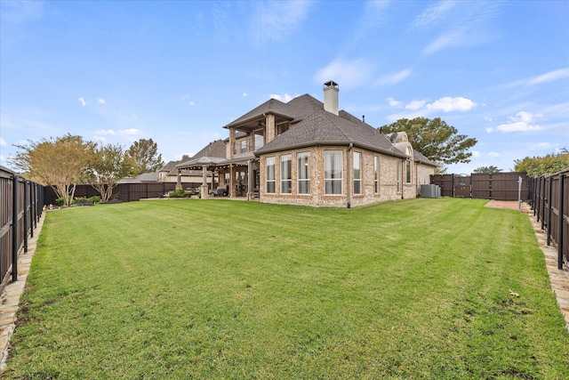 rear view of property featuring central air condition unit and a lawn