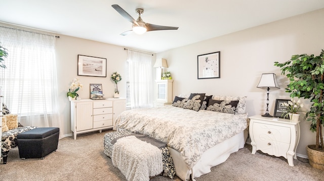 bedroom with light carpet, multiple windows, and ceiling fan