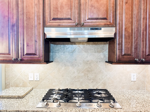 kitchen featuring light stone countertops, stainless steel gas stovetop, and tasteful backsplash