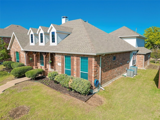 view of front of house with a front lawn and central AC