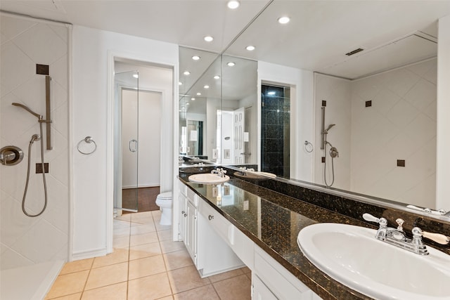 bathroom featuring toilet, vanity, an enclosed shower, and tile patterned flooring