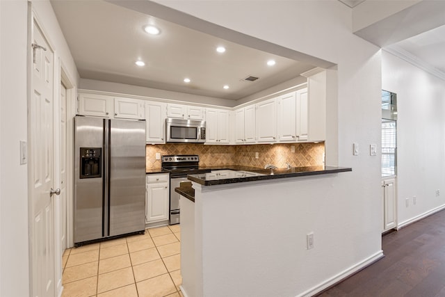 kitchen featuring stainless steel appliances, white cabinets, light wood-type flooring, and kitchen peninsula