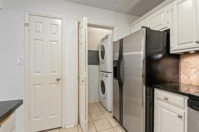 laundry area with light tile patterned flooring and stacked washer and clothes dryer