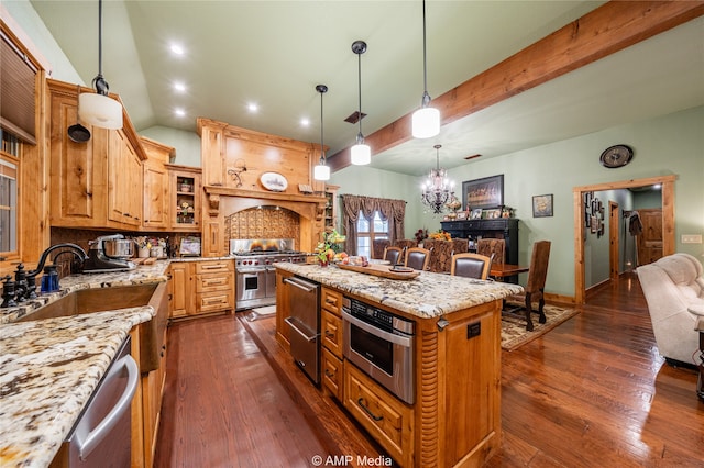 kitchen with appliances with stainless steel finishes, dark wood-type flooring, sink, and a center island