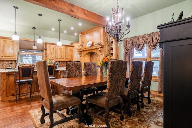 dining space with wood-type flooring, a chandelier, and sink