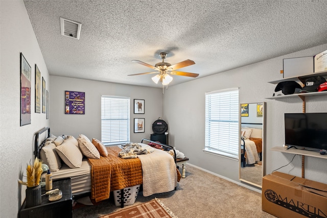 carpeted bedroom with ceiling fan and a textured ceiling