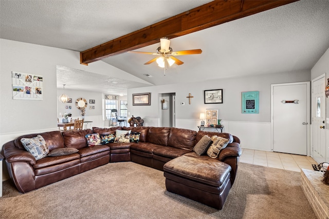 living room featuring lofted ceiling with beams, a textured ceiling, light colored carpet, and ceiling fan