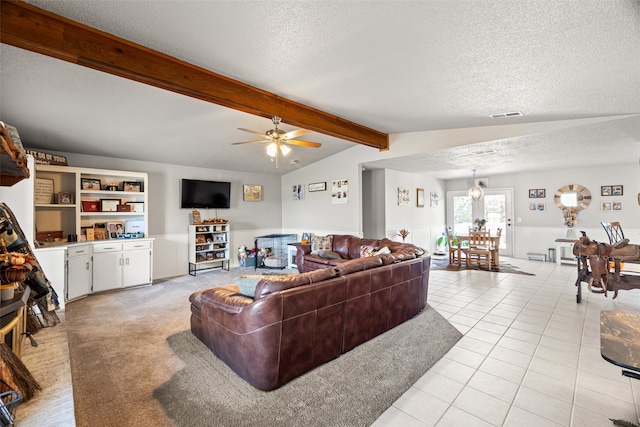 tiled living room with vaulted ceiling with beams, a textured ceiling, and ceiling fan