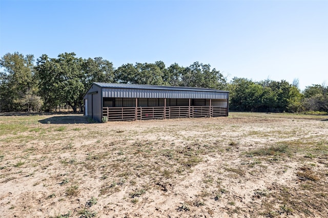 view of horse barn with a rural view