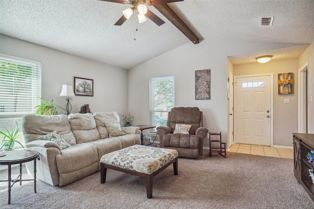 living room with vaulted ceiling with beams, plenty of natural light, ceiling fan, and light colored carpet