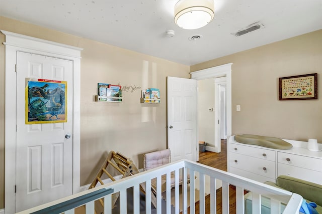 interior space featuring hardwood / wood-style flooring and a crib