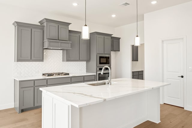 kitchen with stainless steel appliances, visible vents, a sink, and gray cabinetry