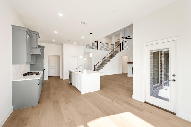 kitchen with light countertops, light wood-type flooring, a sink, and gray cabinetry