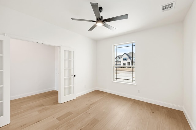 unfurnished room featuring light wood finished floors, baseboards, and visible vents