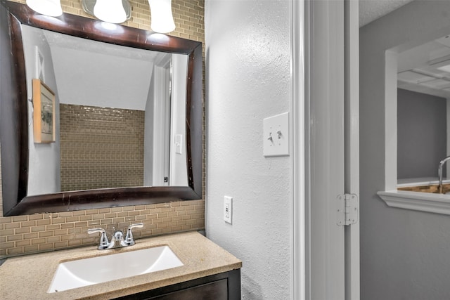 bathroom featuring vanity and tasteful backsplash