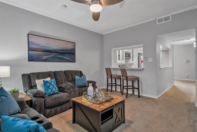 carpeted living room featuring ceiling fan, a textured ceiling, and ornamental molding