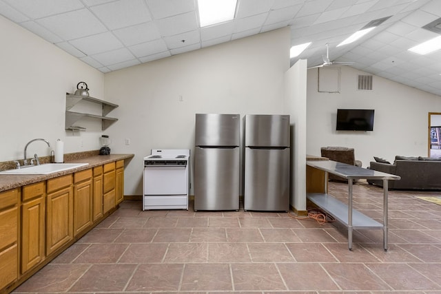 kitchen featuring a drop ceiling, sink, stainless steel refrigerator, and white range oven