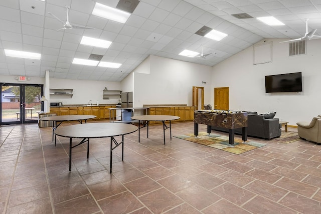 recreation room featuring a high ceiling, a paneled ceiling, and french doors