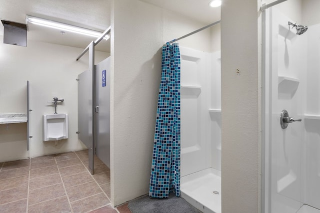 bathroom with a shower with shower curtain and tile patterned floors