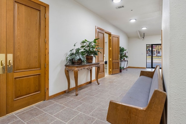 hall featuring lofted ceiling