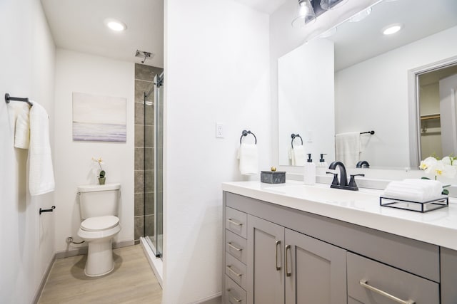 bathroom featuring hardwood / wood-style floors, toilet, an enclosed shower, and vanity