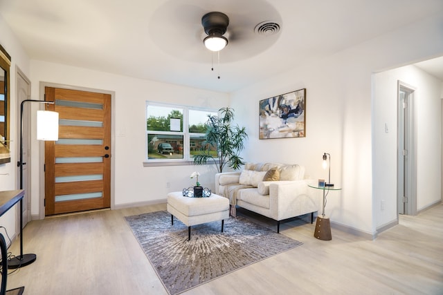 living area with ceiling fan and light hardwood / wood-style flooring