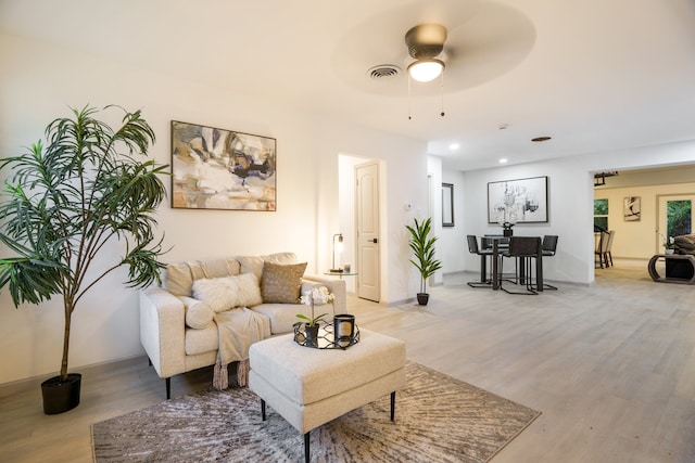 living room featuring ceiling fan and light hardwood / wood-style flooring