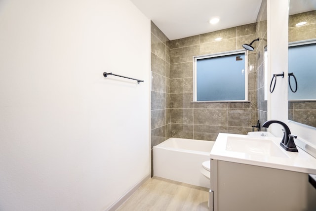 full bathroom featuring wood-type flooring, vanity, toilet, and tiled shower / bath