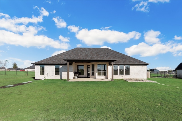 rear view of house featuring a patio and a lawn