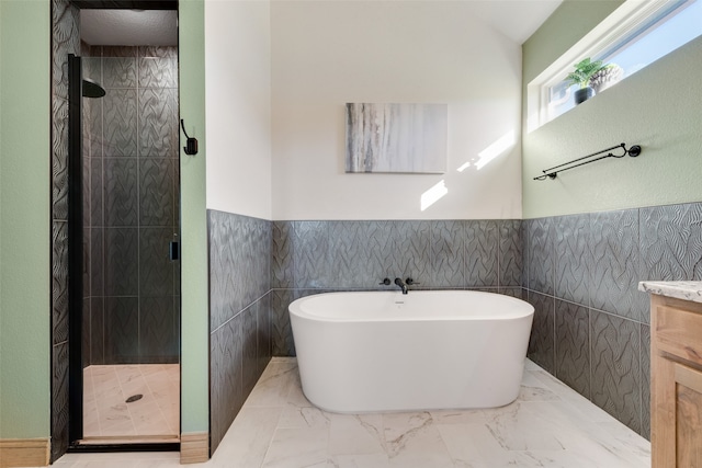 bathroom featuring vanity, separate shower and tub, and tile walls