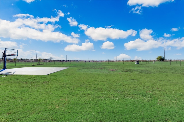 view of yard featuring basketball hoop and a rural view