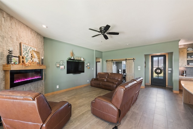 living room with ornamental molding, a barn door, light tile patterned floors, and ceiling fan