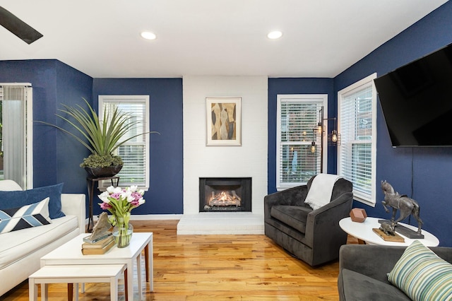 living room featuring a healthy amount of sunlight, a fireplace, and wood-type flooring