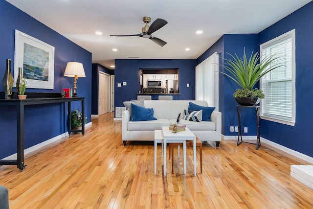 living room with light wood-type flooring and ceiling fan