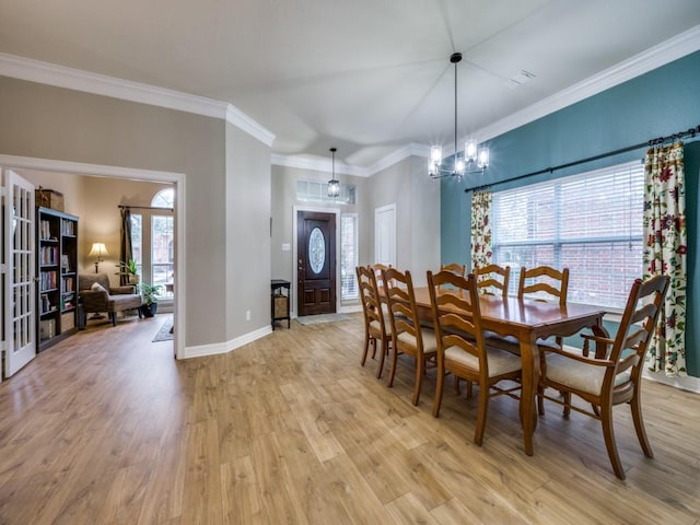 dining area featuring a chandelier, light hardwood / wood-style floors, plenty of natural light, and ornamental molding