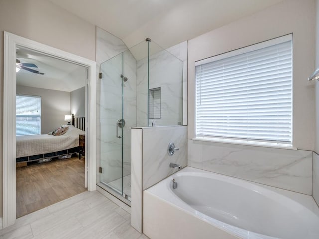 bathroom with hardwood / wood-style floors, ceiling fan, shower with separate bathtub, and vaulted ceiling