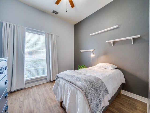 bedroom with light wood-type flooring, multiple windows, and ceiling fan