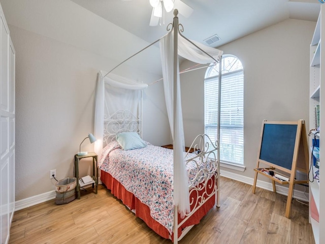 bedroom featuring hardwood / wood-style flooring, ceiling fan, vaulted ceiling, and multiple windows