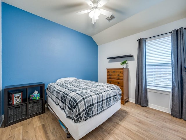 bedroom featuring ceiling fan, light hardwood / wood-style flooring, and lofted ceiling