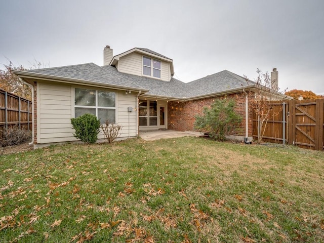 back of property featuring a lawn and a patio