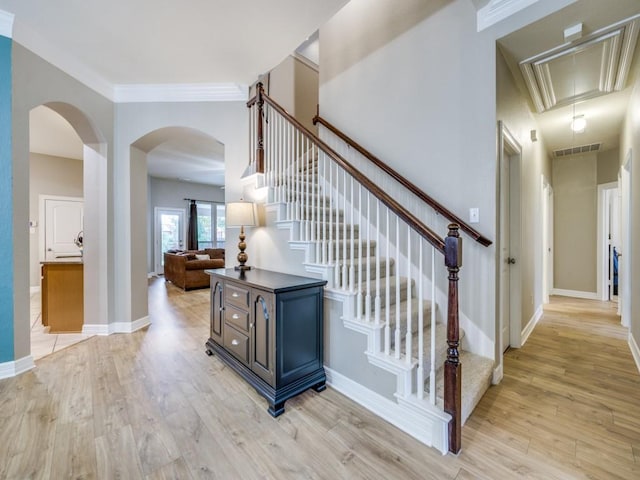 stairway featuring hardwood / wood-style floors and crown molding