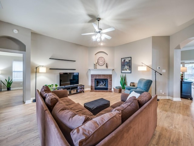 living room with a fireplace, plenty of natural light, and light wood-type flooring