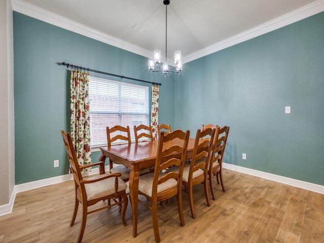 dining area featuring crown molding, a notable chandelier, and light wood-type flooring