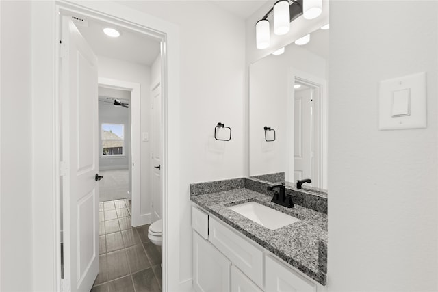 bathroom with tile patterned flooring, ceiling fan, toilet, and vanity