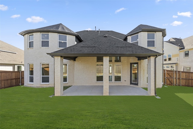 rear view of house featuring a yard and a patio