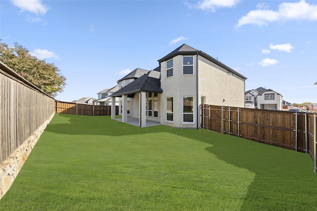 back of property with a patio area and a yard