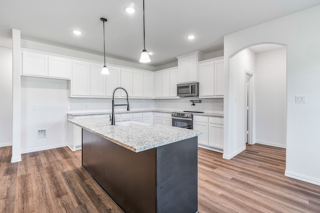 kitchen featuring dark wood-style flooring, baseboards, stainless steel appliances, and a sink