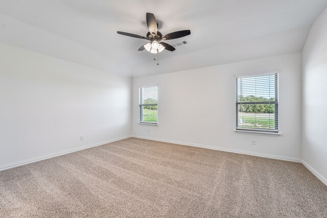 carpeted spare room with ceiling fan, baseboards, and visible vents